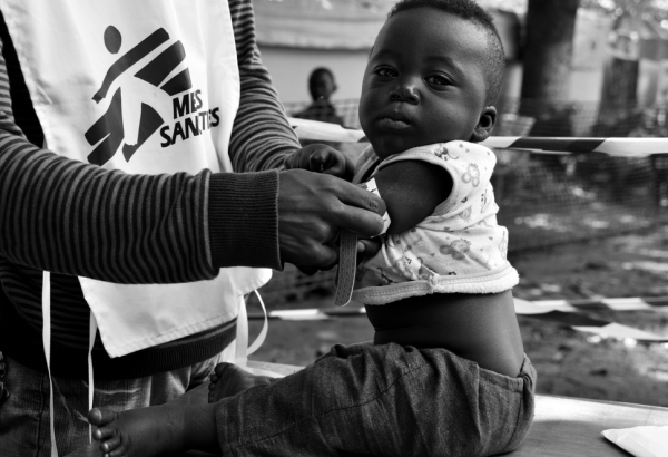 Um profissional de saúde em meio a uma campanha de vacinação para deslocados internos em Bangui, na República Centro-Africana (RCA). Na mesquita da cidade, onde milhares de pessoas se reuniram, MSF ofereceu vacinas contra doenças, incluindo a pneumonia. Por todo mundo, uma em cada cinco crianças não é totalmente vacinada. (Foto: Aurelie Baumel/MSF)